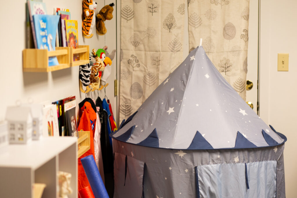 An IKEA play tent surrounded by children's toys.